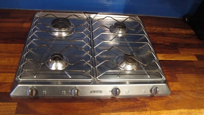 a-metallic-stove-installed-on-top-of-a-wooden-kitchen-counter